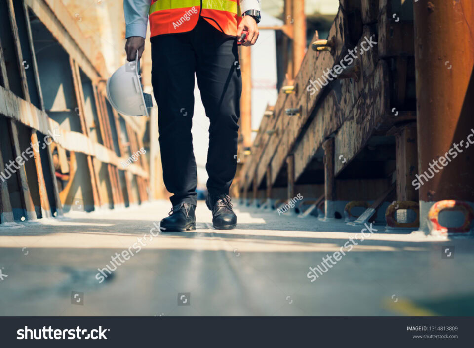 stock photo foreman using walkie talkie and safety boots to work in cargo ship 1314813809